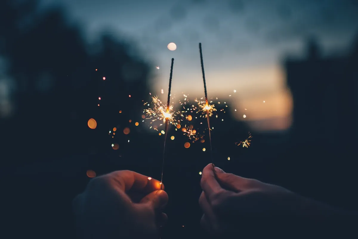 Friends holding sparklers at an evening celebration
